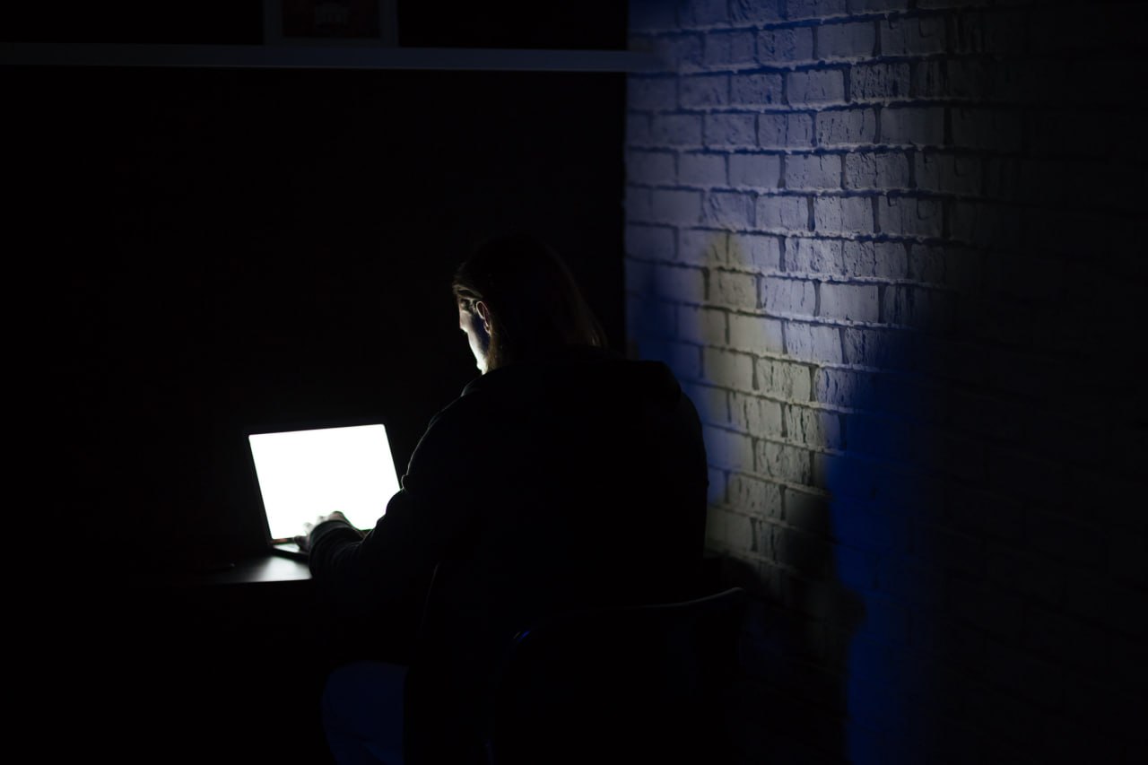 A boy alone with a laptop in the dark